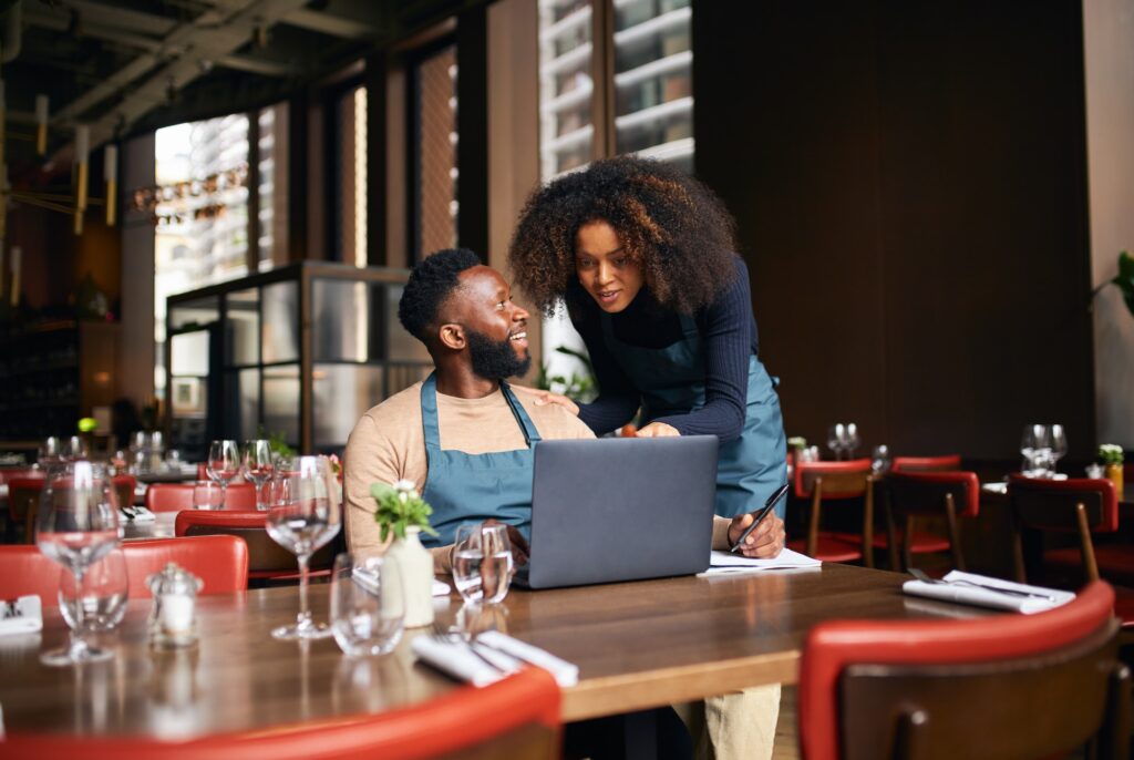 Restaurant owners working with laptop