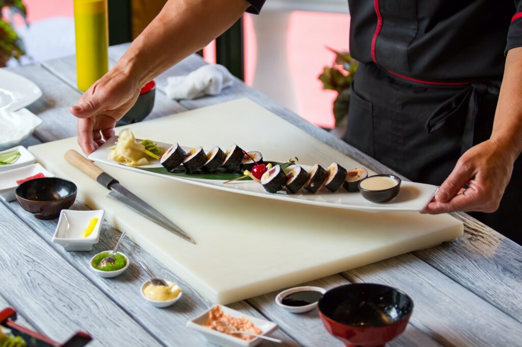 Hands holding plate with sushi