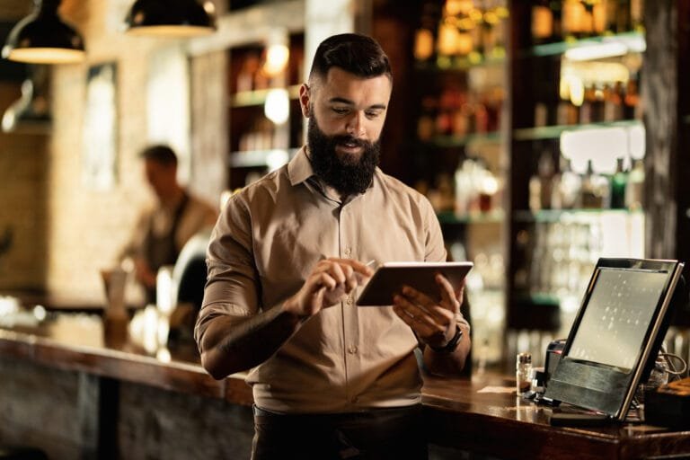 Barista utilizando um tablet durante o trabalho no bar