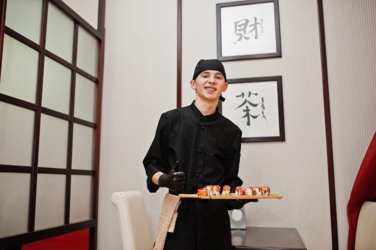 Chef com seleção de sushis e rolls em restaurante japonês