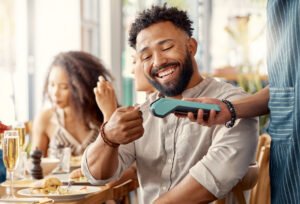 Cliente realizando pagamento no restaurante e participando do programa de fidelidade