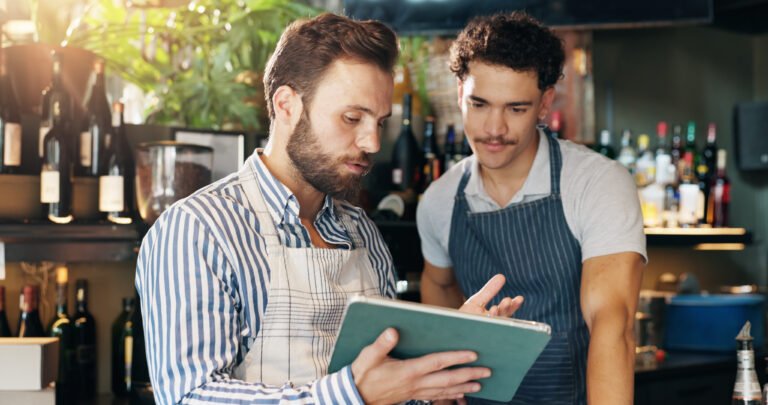Profissionais de restaurante analisando a escala e a operação em um tablet