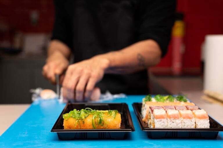Profissional preparando um pedido de sushi para viagem no restaurante japonês